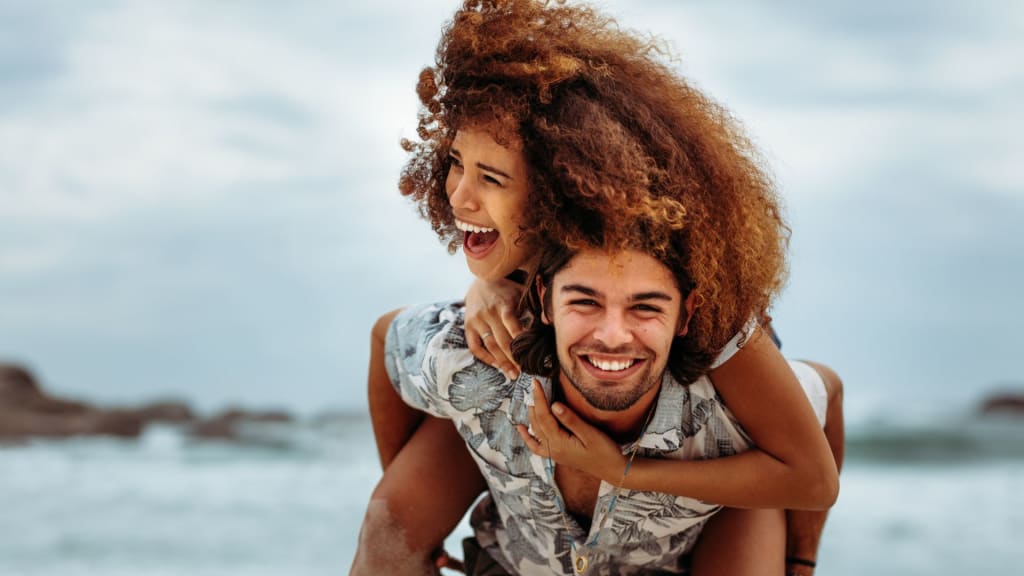 Couple Piggybacking at the Beach